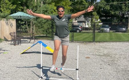 Person jumping over agility equipment